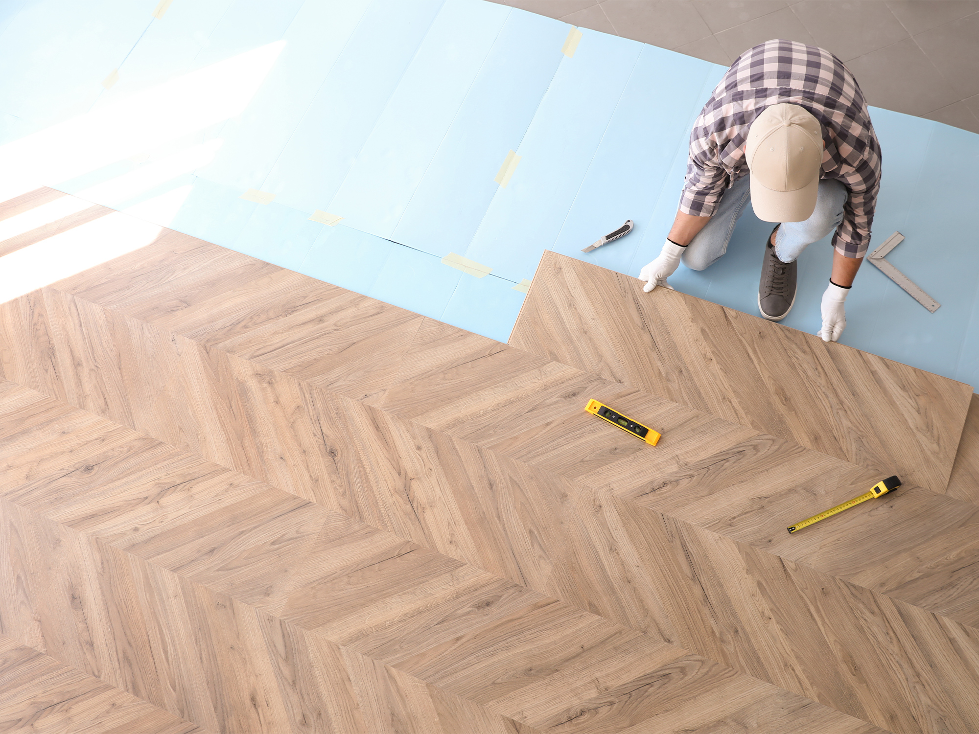 man measuring a floor with measuring tools